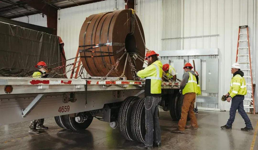 A training class securing a load to a flatbed trailer.